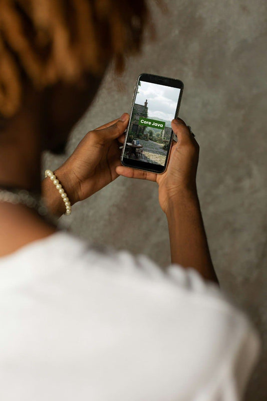 Person holding a smartphone with a screen displaying an Java PDF course 'Core Java' interface.