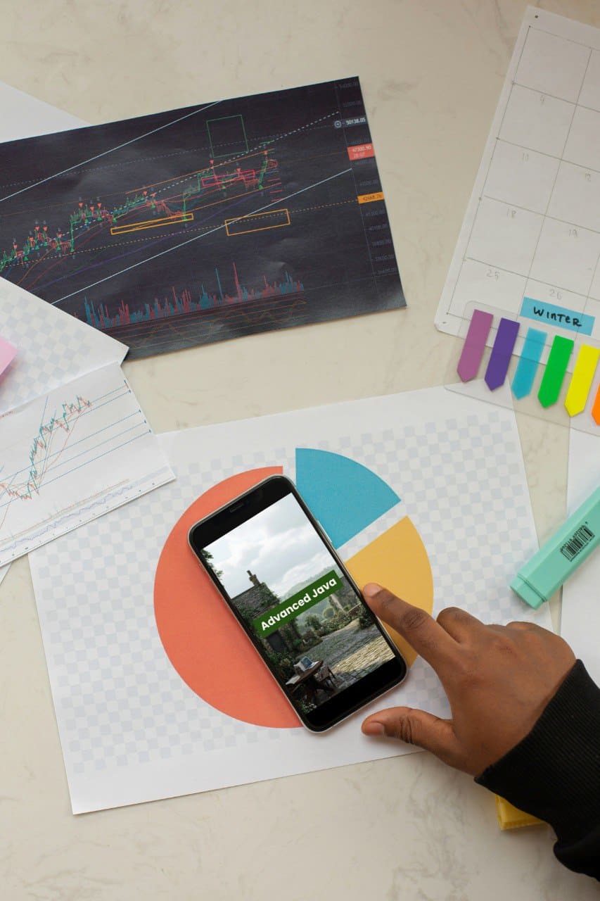 Person using a smartphone with a 'Advanced Java' course interface on a desk with stationery items.