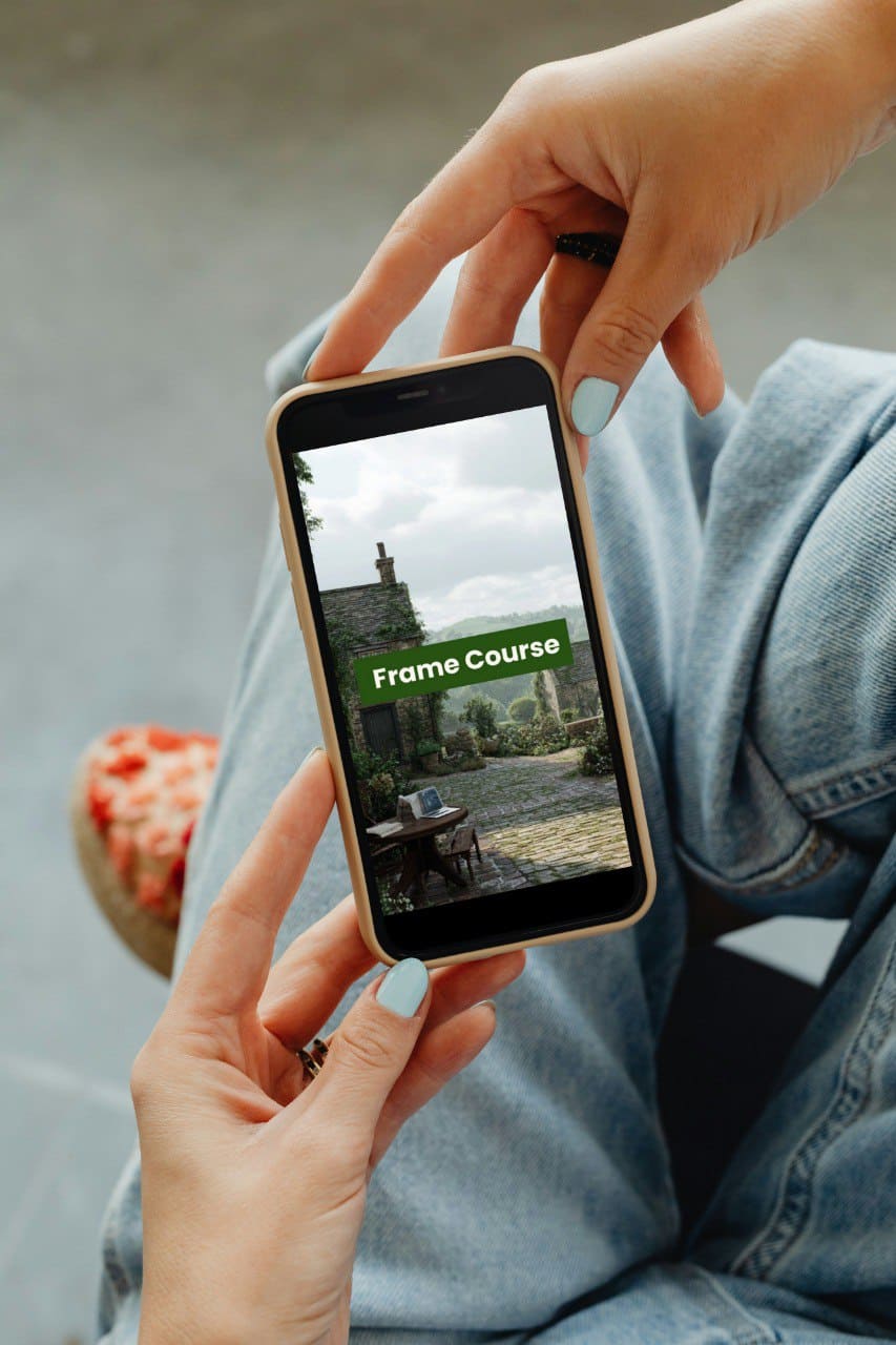 Person holding a smartphone with an app displaying a 'Frame Course' on the screen.