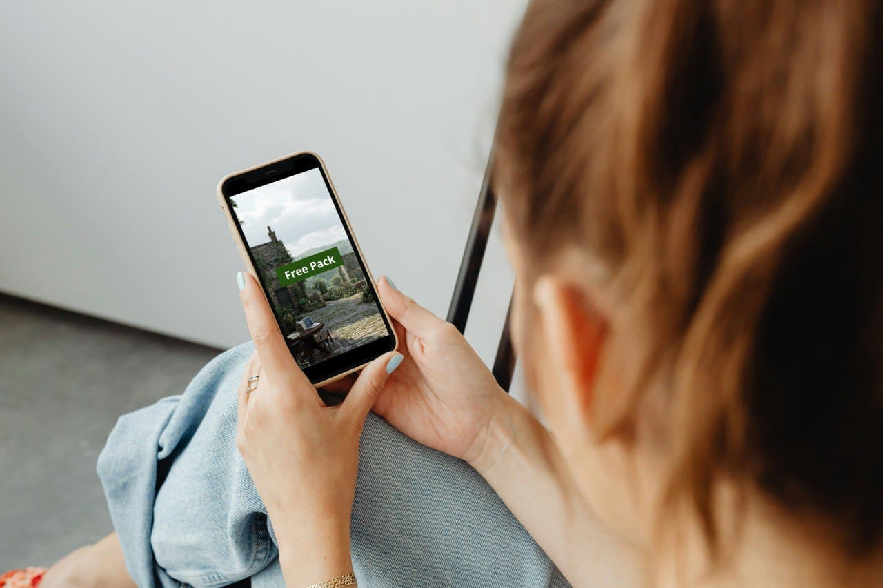 Person holding a smartphone with a screen displaying an Java PDF course 'Free Pack'.