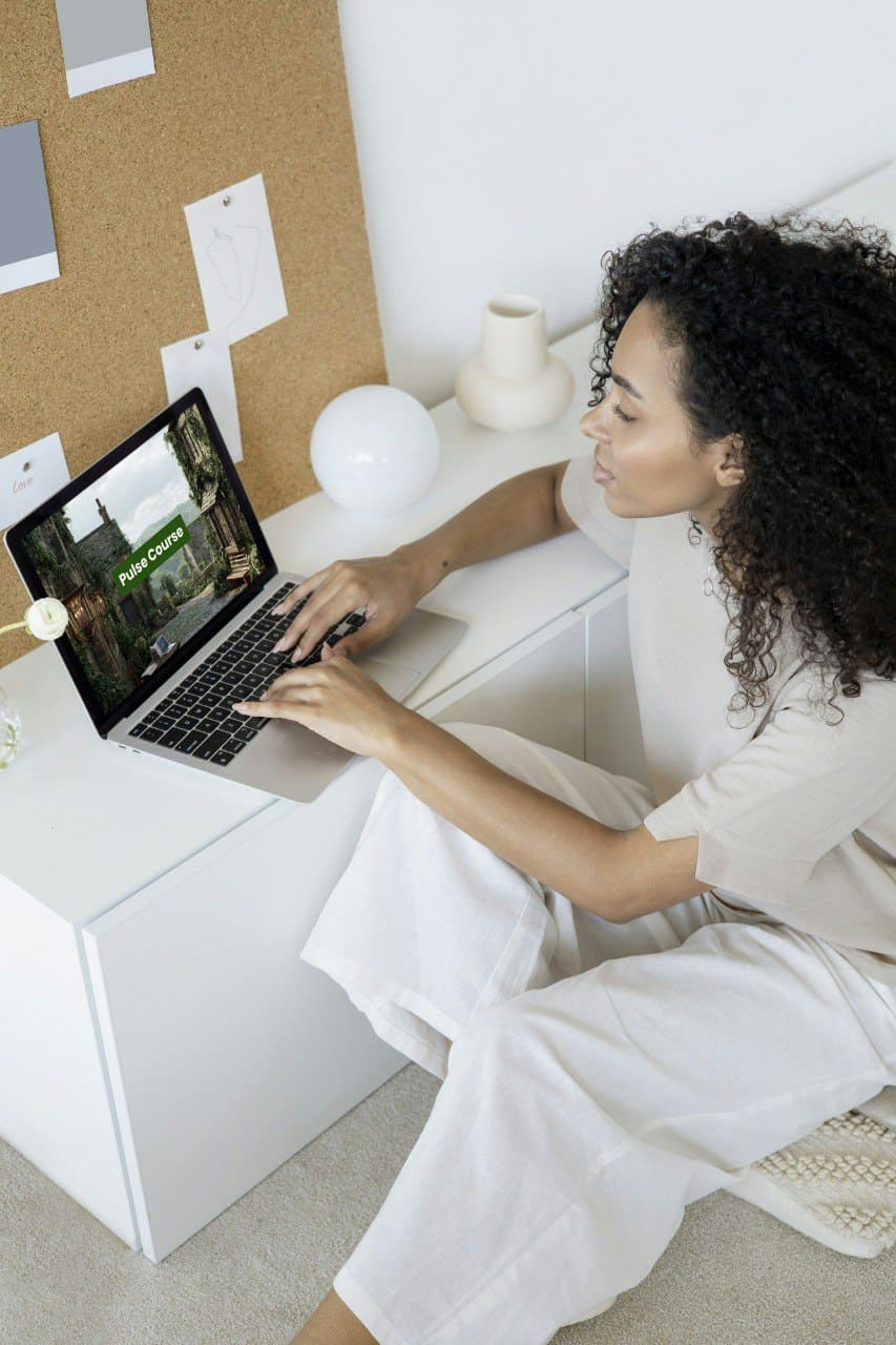 Woman sitting with laptop displaying PDF Java course 'Pulse Course'